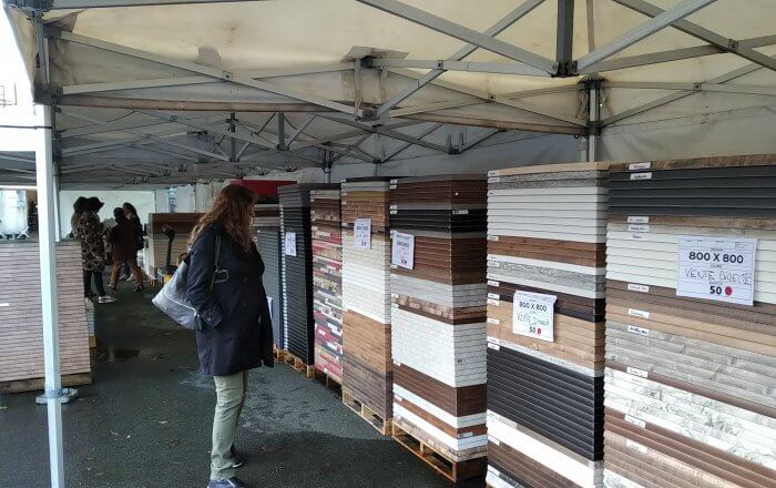 Photo d'une vente de plateaux de table sur le parking de l'entreprise, sous tivoli.