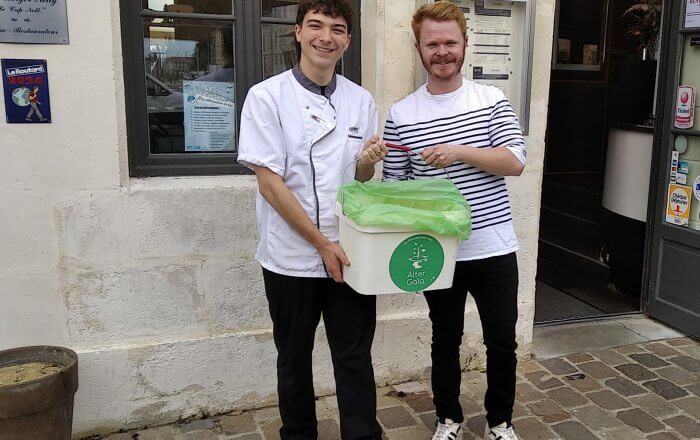 Photo de l'équipe du Cap Nell avec le seau de biodéchets devant leur restaurant